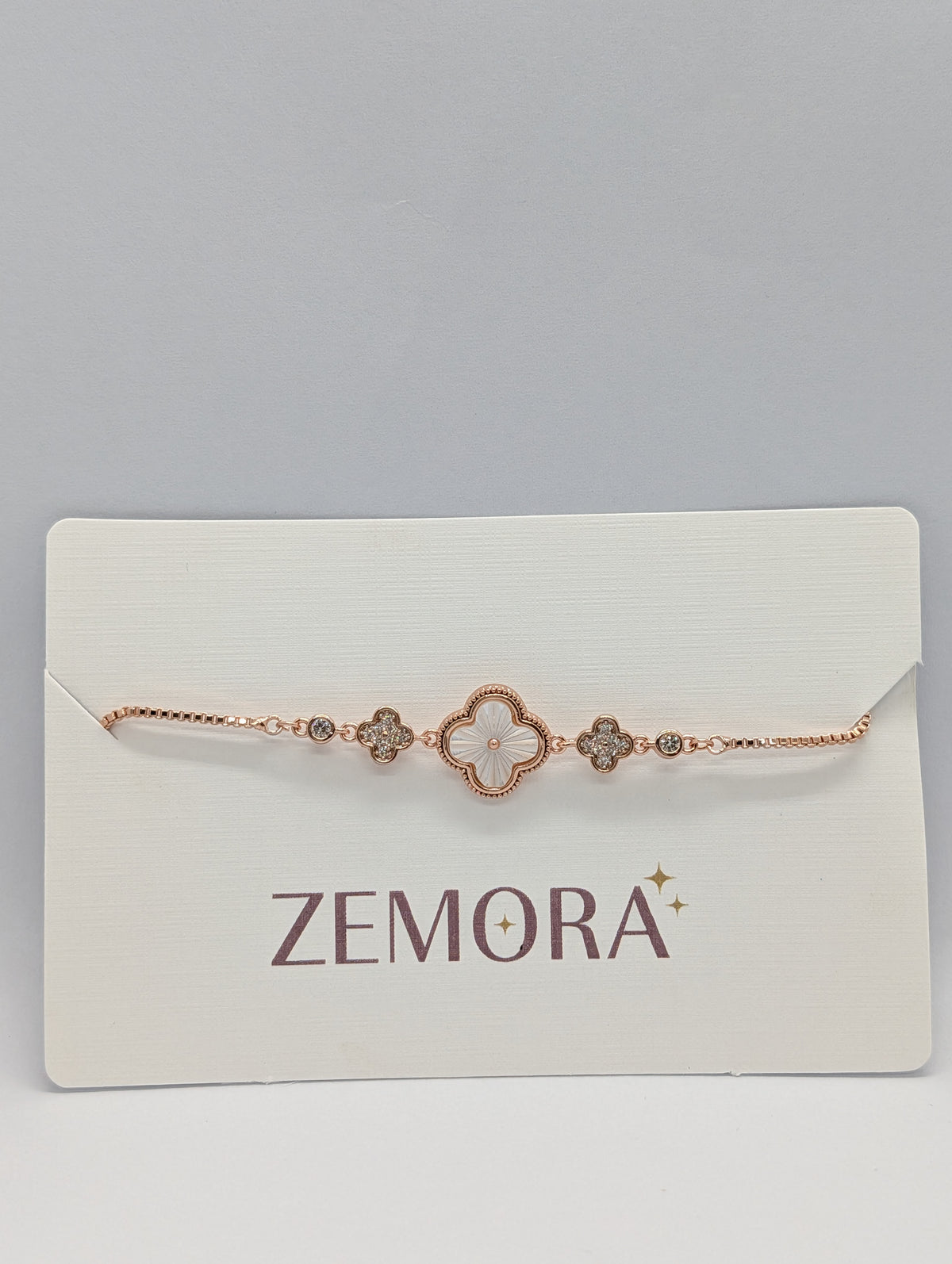 Rose gold mother of pearl clover charm station bracelet on Zemora jewellery card