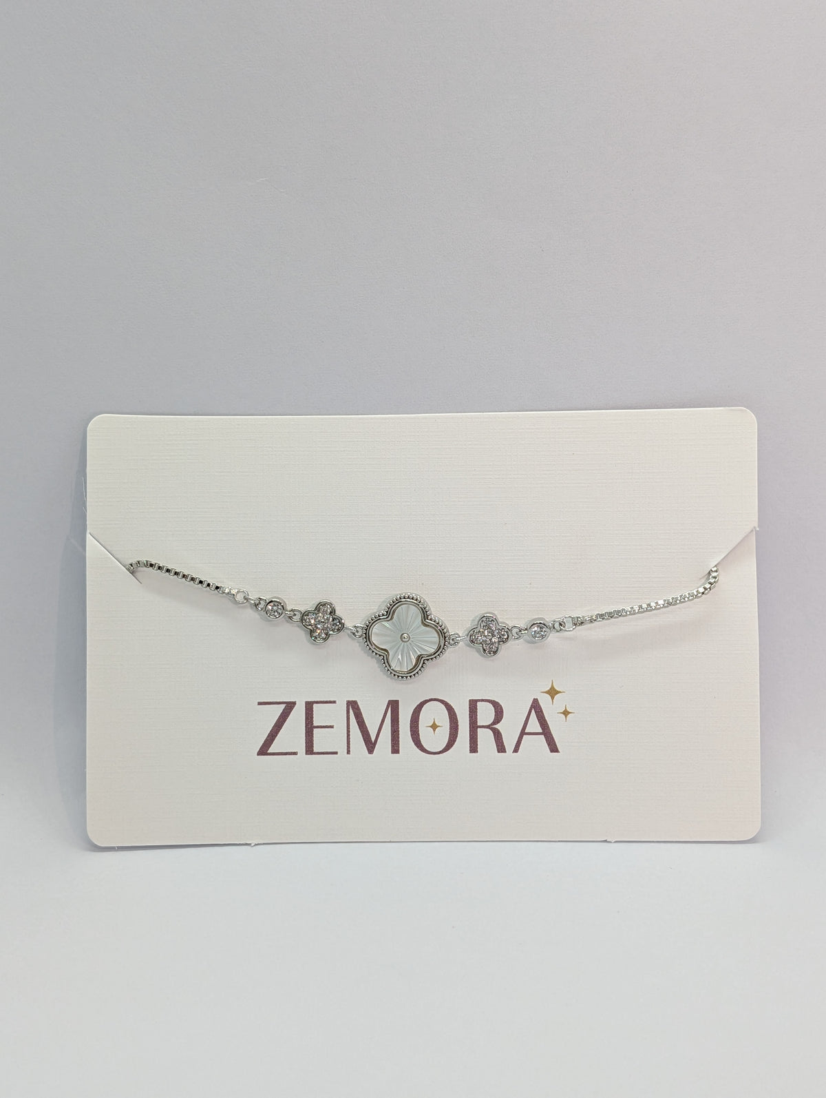 Silver mother of pearl clover charm station bracelet on Zemora jewellery card