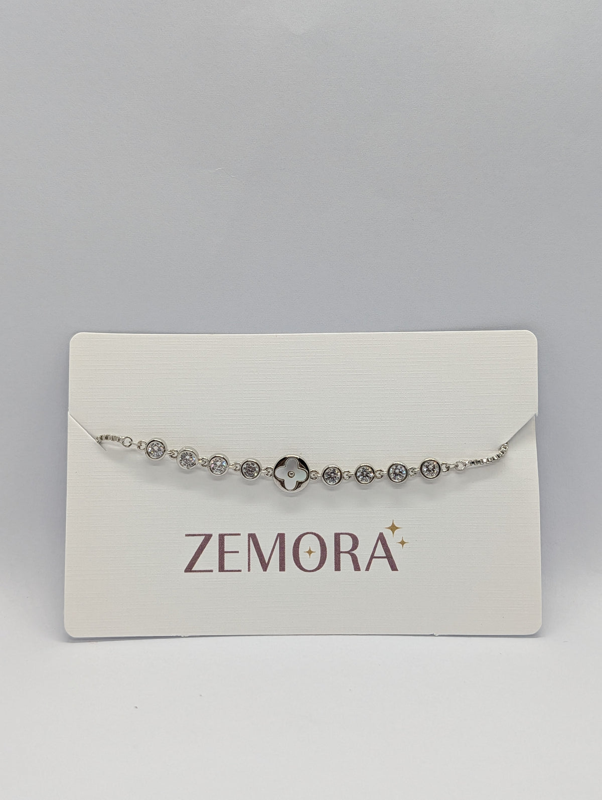 Silver CZ bezel clover charm station adjustable bracelet on Zemora jewellery card