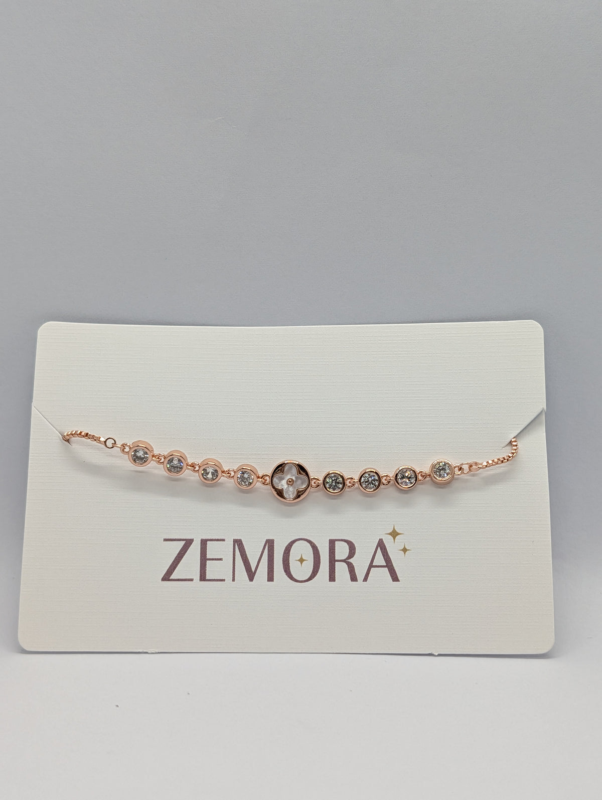 Yellow gold CZ bezel clover charm station adjustable bracelet on Zemora jewellery card