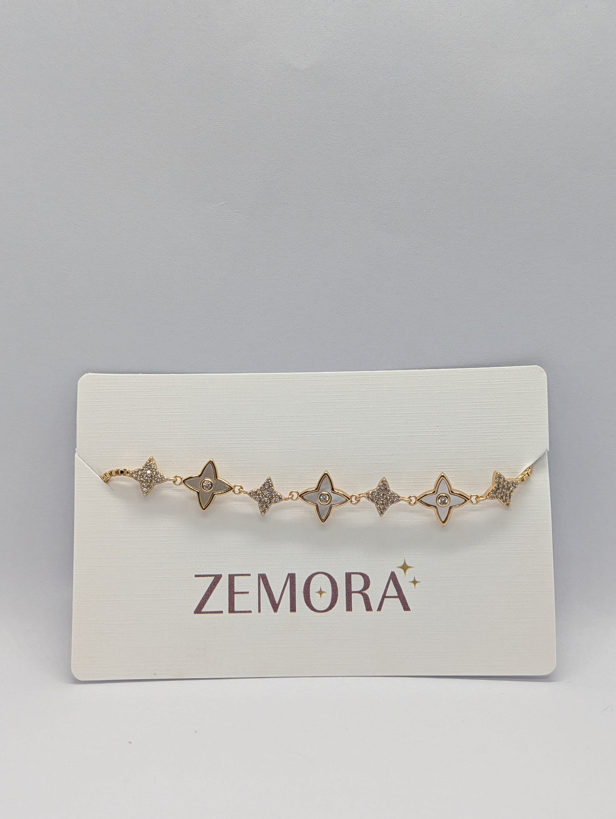 Rose gold CZ pavé star charm station adjustable bracelet flat lay with bolo slider detail