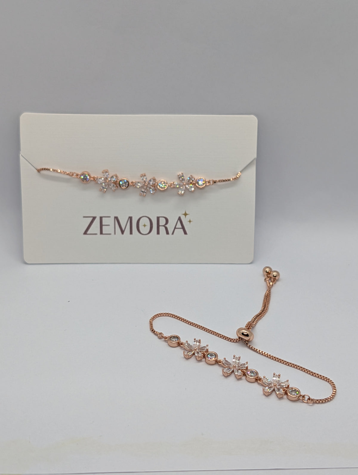 Rose gold CZ marquise flower bezel station adjustable bracelet flat lay with bolo slider