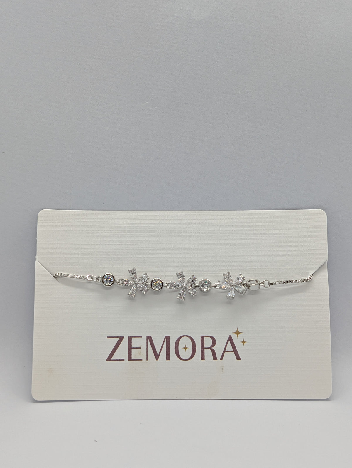 Rose gold CZ marquise flower bezel station bracelet close-up on Zemora card