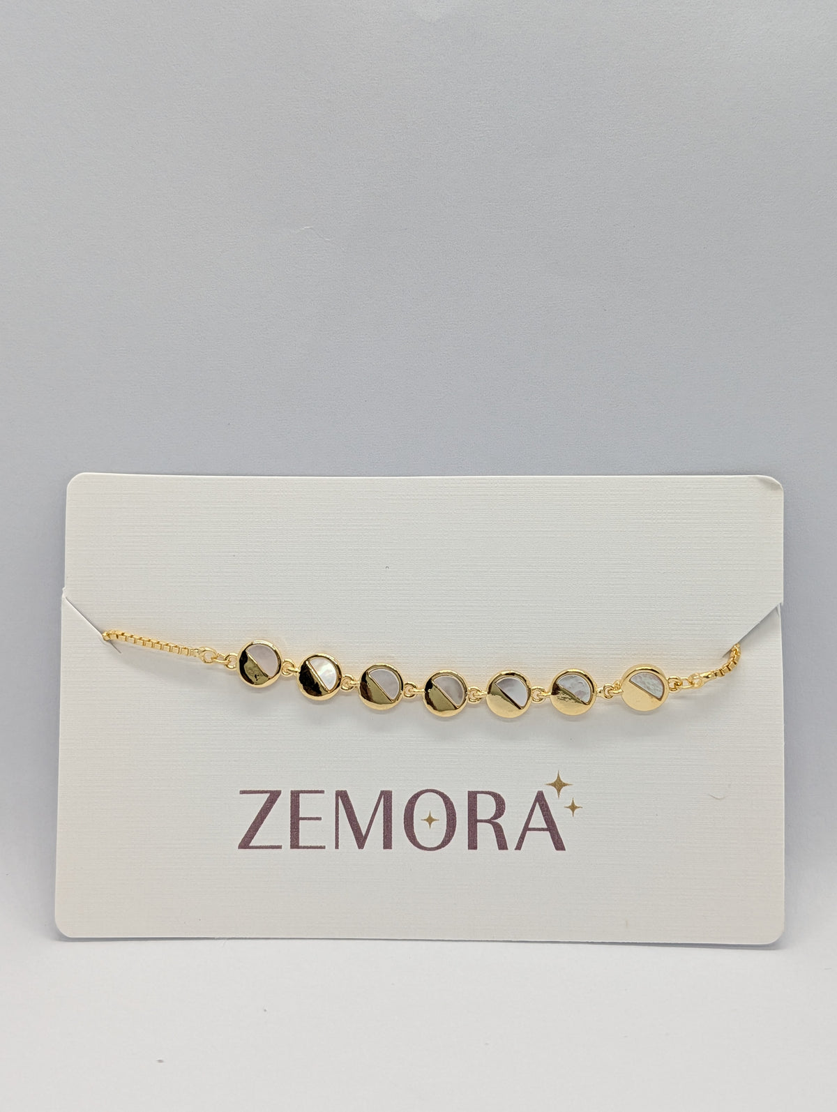Yellow gold mirror disc station adjustable bracelet on Zemora jewellery card