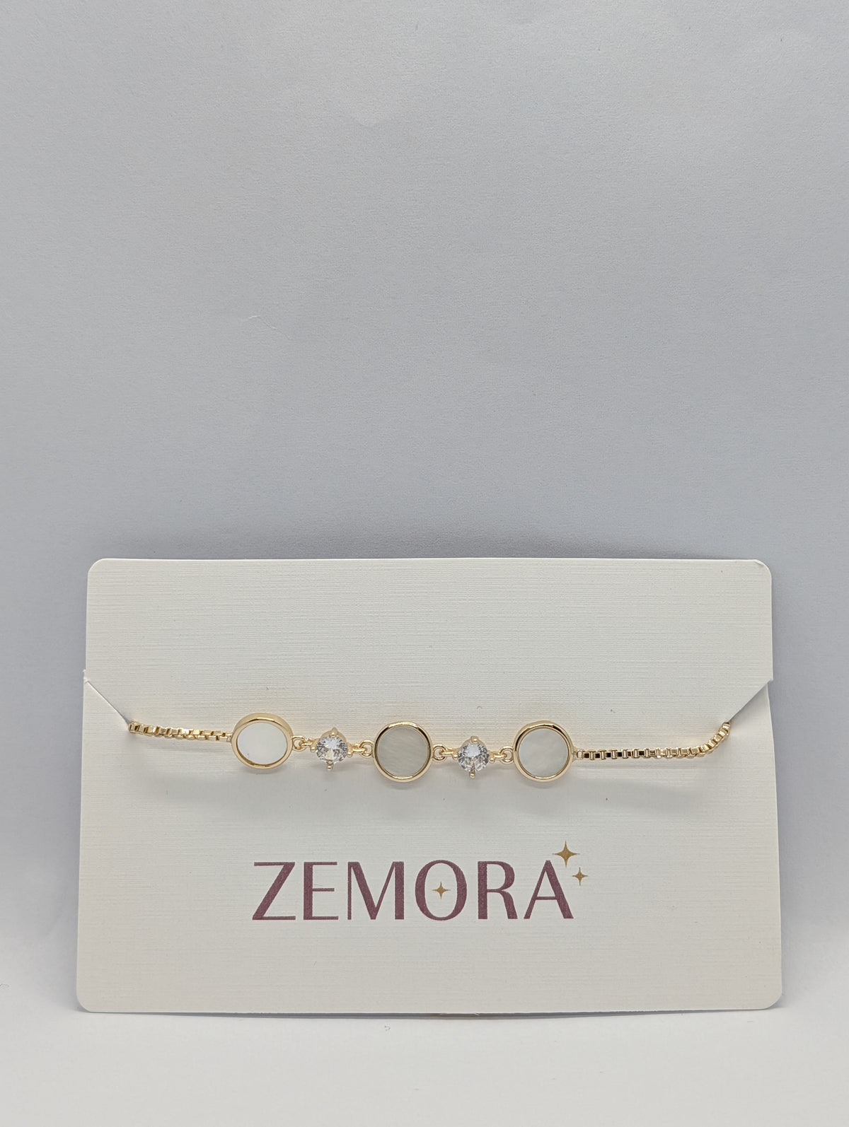 Rose gold luminous shell disc solitaire charm bracelet flat lay with adjustable slider detail