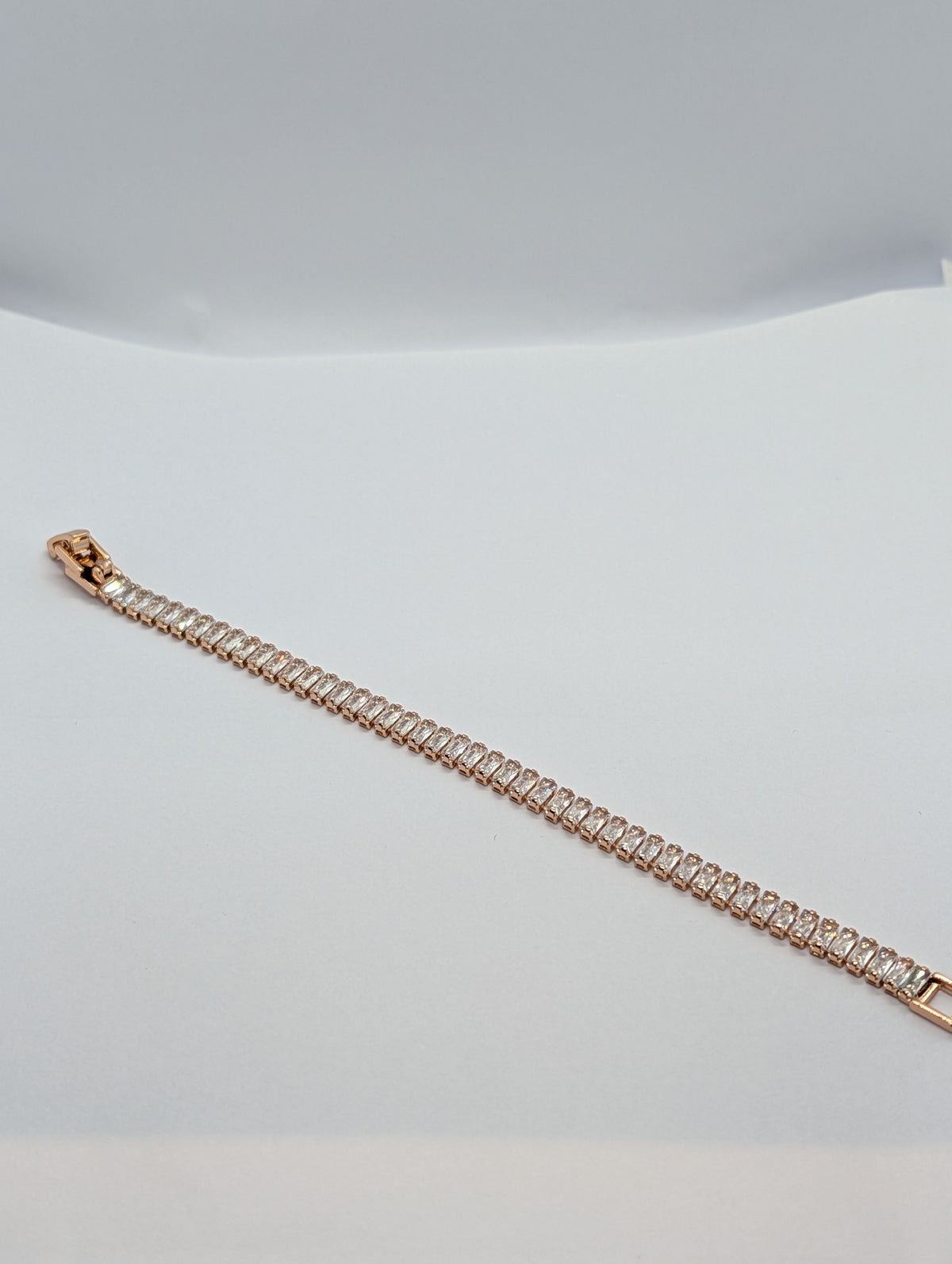 Rose gold baguette row tennis bracelet close-up on Zemora card showing stone sparkle