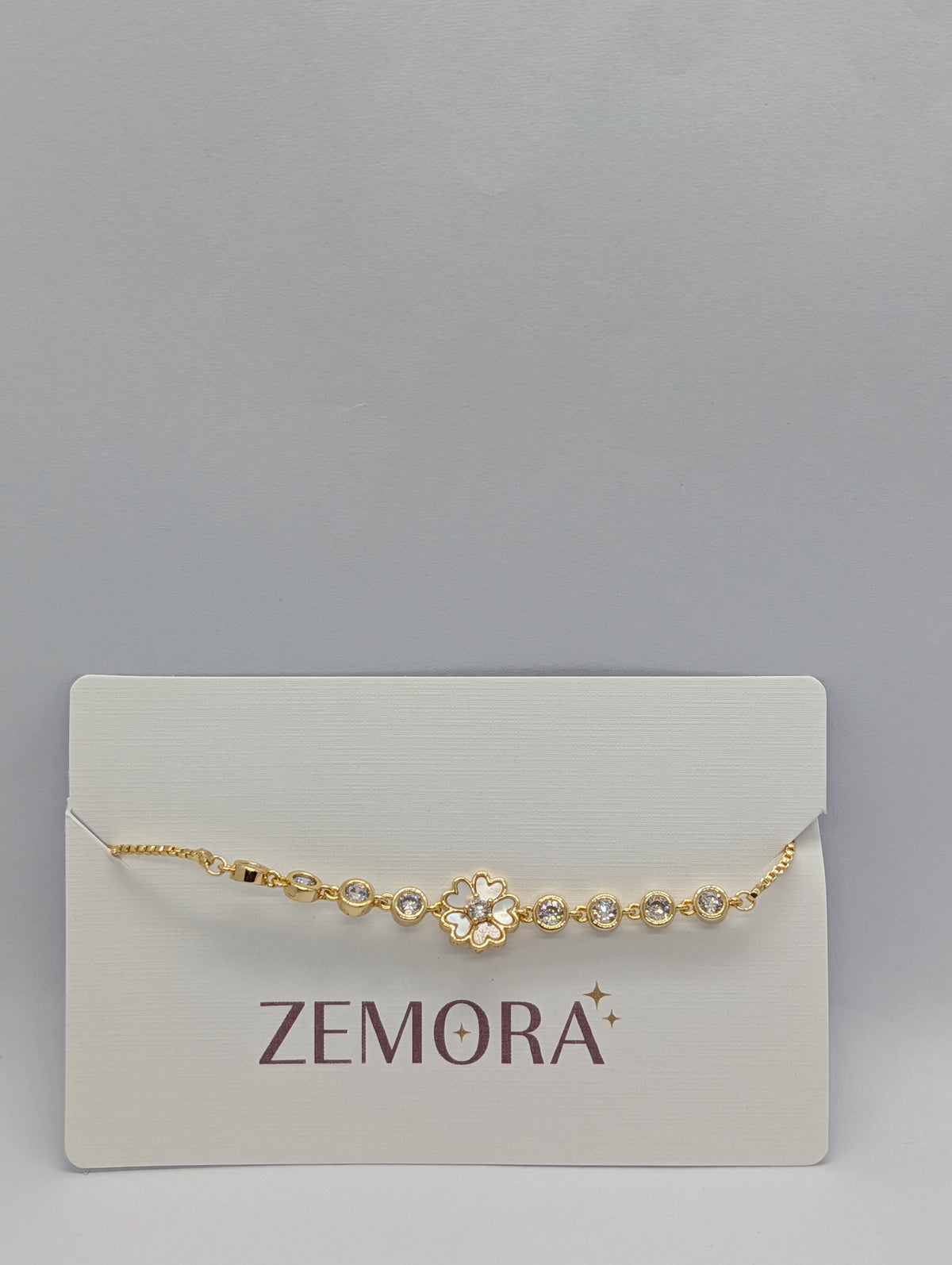 Yellow gold white enamel sakura flower bezel chain bracelet on Zemora jewellery card