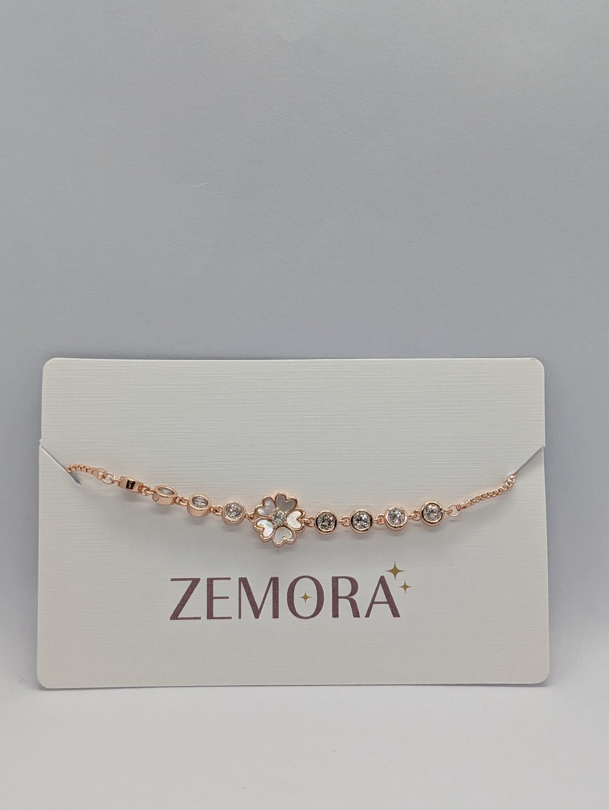 Rose gold white enamel sakura flower bezel chain bracelet on Zemora jewellery card