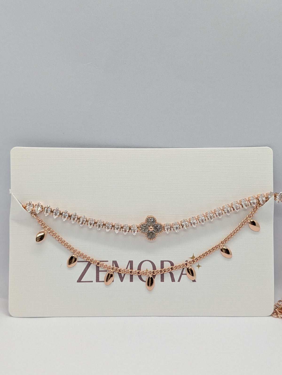 Rose gold double layer clover tennis and teardrop charm bracelet on Zemora jewellery card