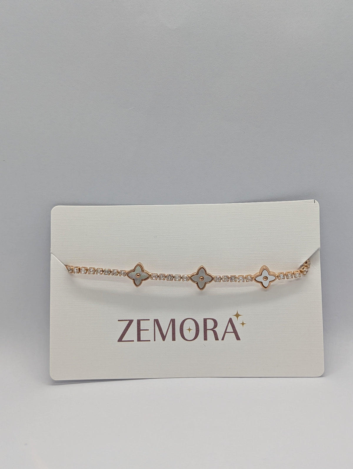 Rose gold pearl quatrefoil station CZ tennis bracelet close angle on Zemora card