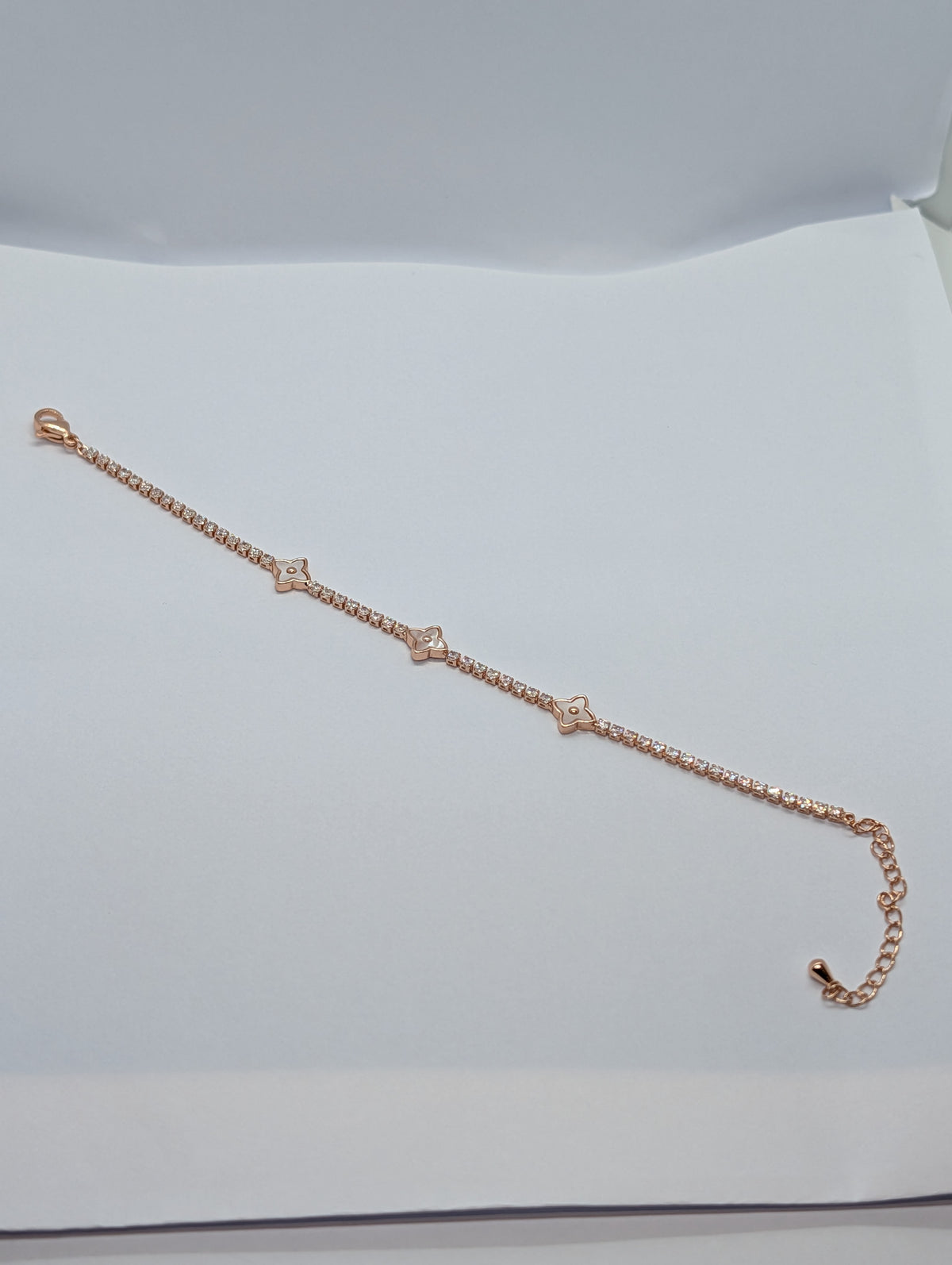 Rose gold and gold pearl quatrefoil station CZ tennis bracelet hero flat lay on Zemora card