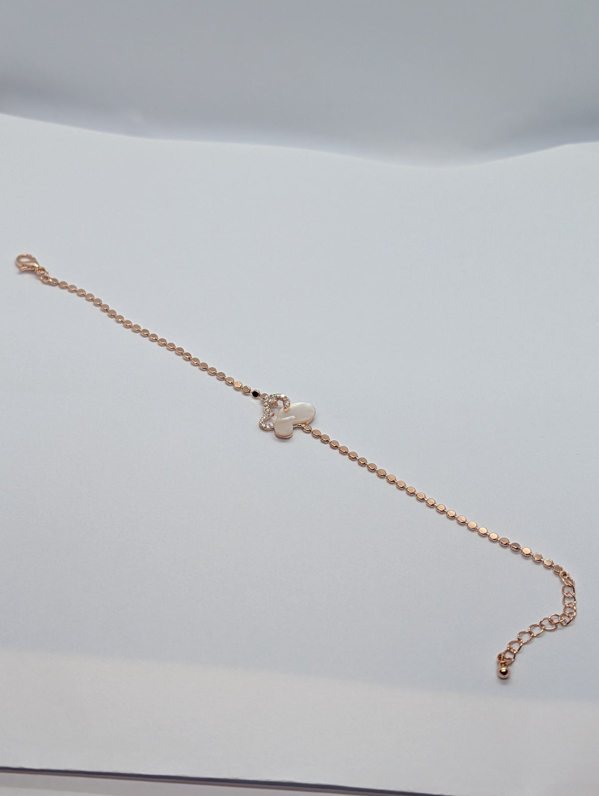 Silver pearl and pavé half butterfly sequin chain bracelet flat lay showing full length and lobster clasp