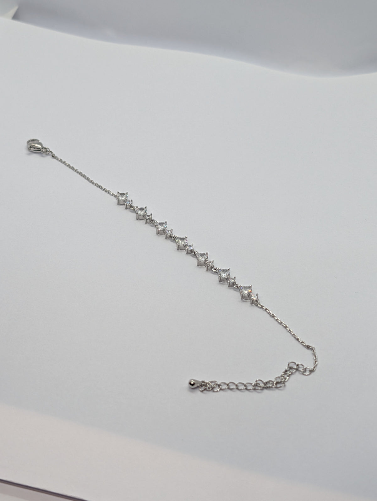 Yellow gold alternating marquise and round CZ station chain bracelet flat lay