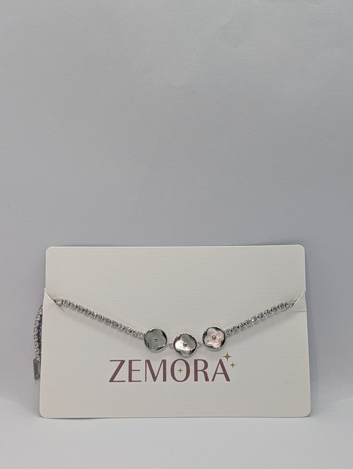 Rose gold dual-tone pearl clover trio CZ tennis bracelet flat lay full length with box clasp