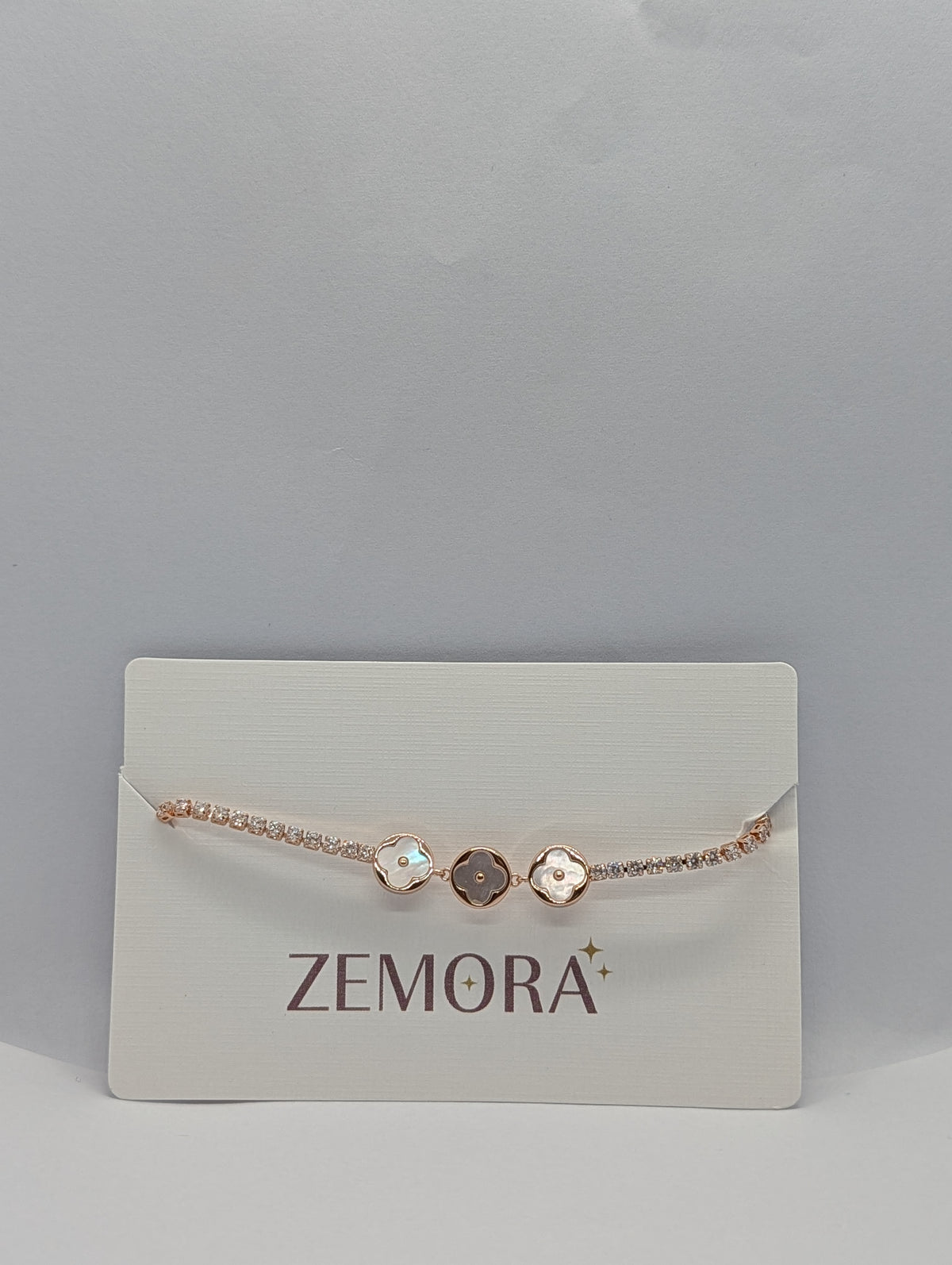 Silver dual-tone pearl clover trio CZ tennis bracelet flat lay full length with box clasp