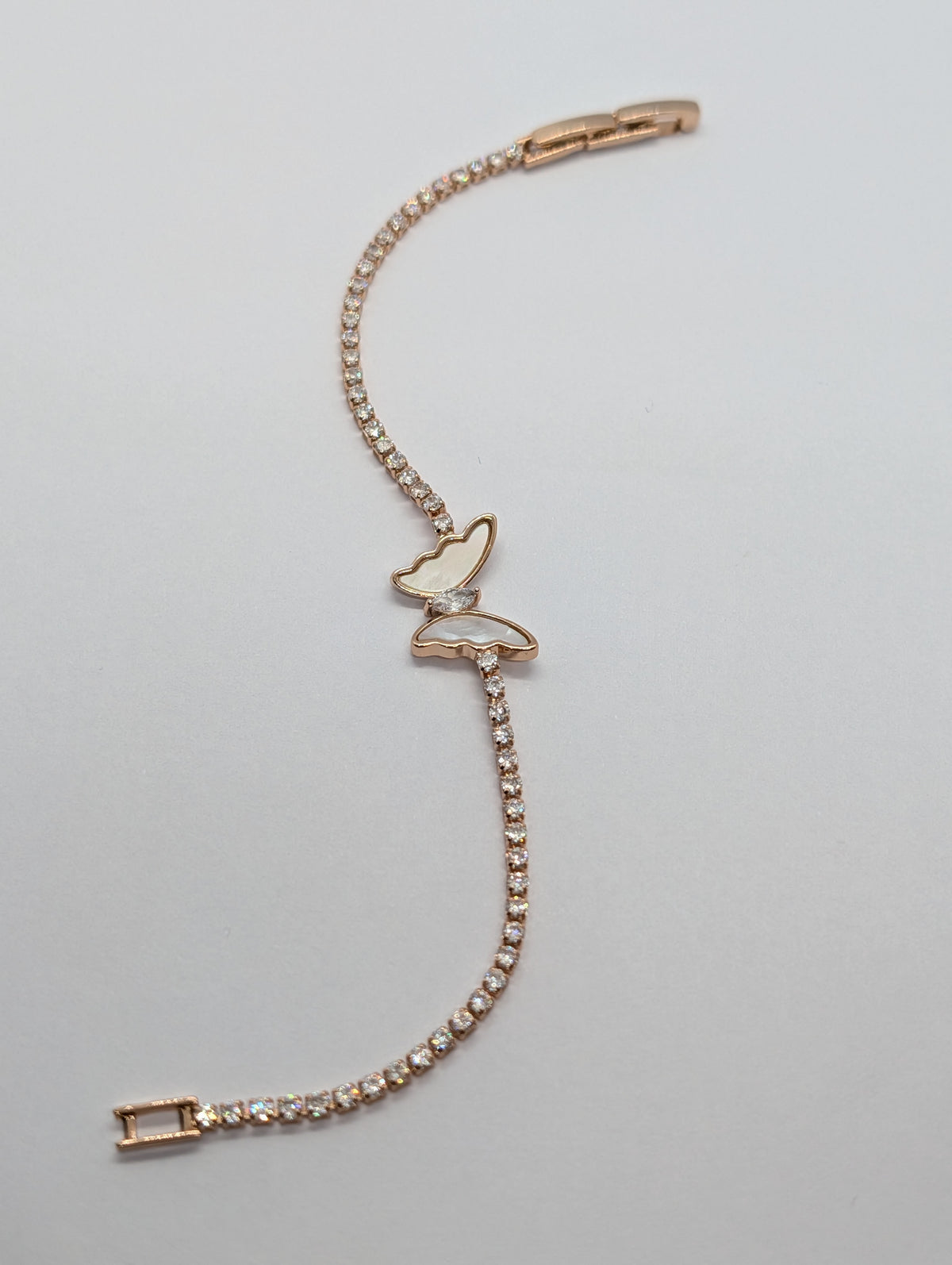 Gold mother of pearl butterfly station CZ tennis bracelet flat lay showing full length and box clasp