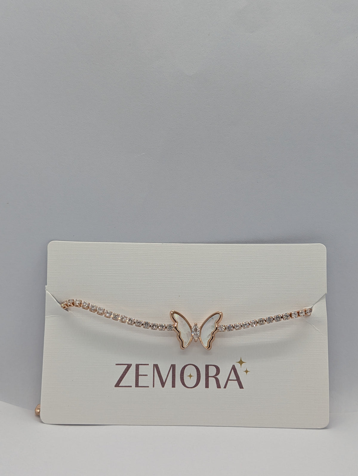 Rose gold mother of pearl butterfly station CZ tennis bracelet flat lay