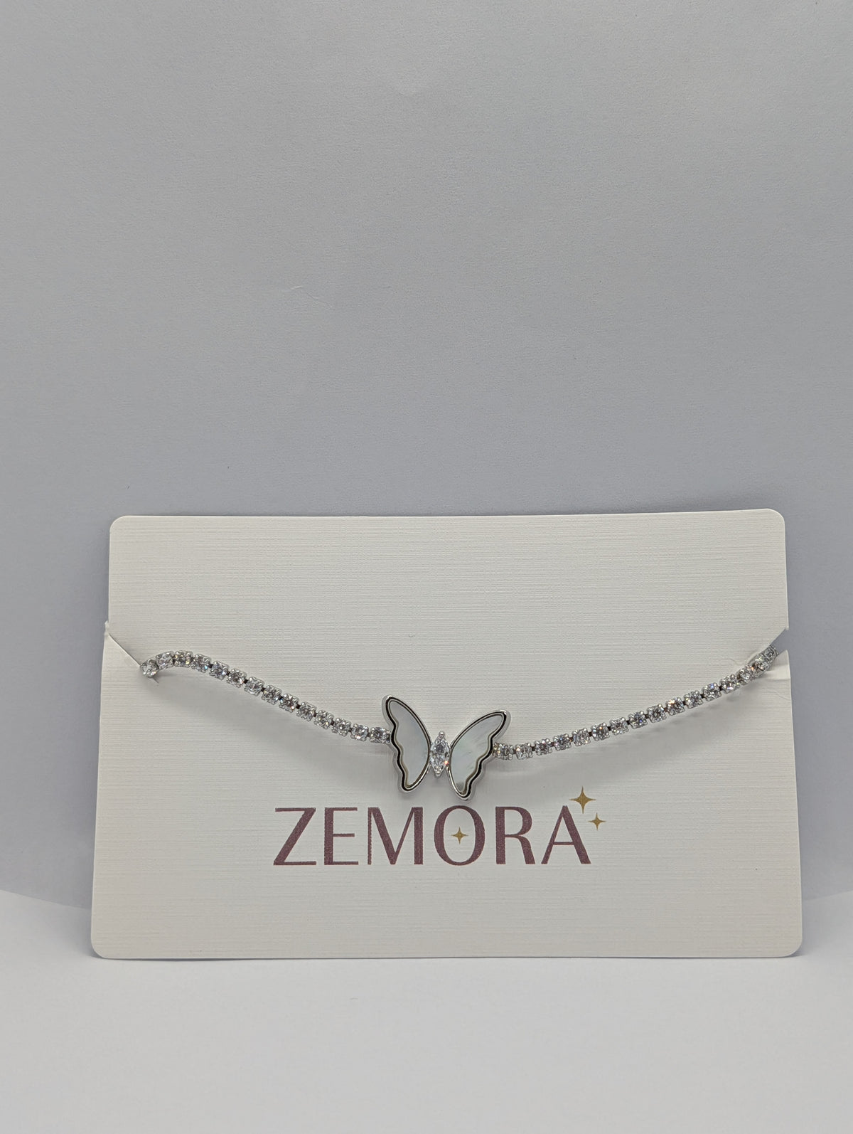 Silver mother of pearl butterfly station CZ tennis bracelet flat lay
