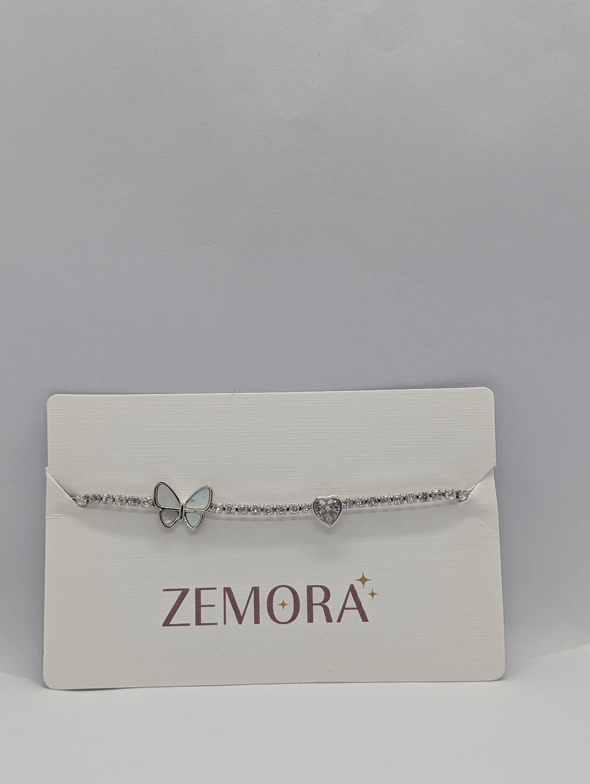 Gold butterfly heart duo station CZ tennis bracelet flat lay showing full length and extender chain