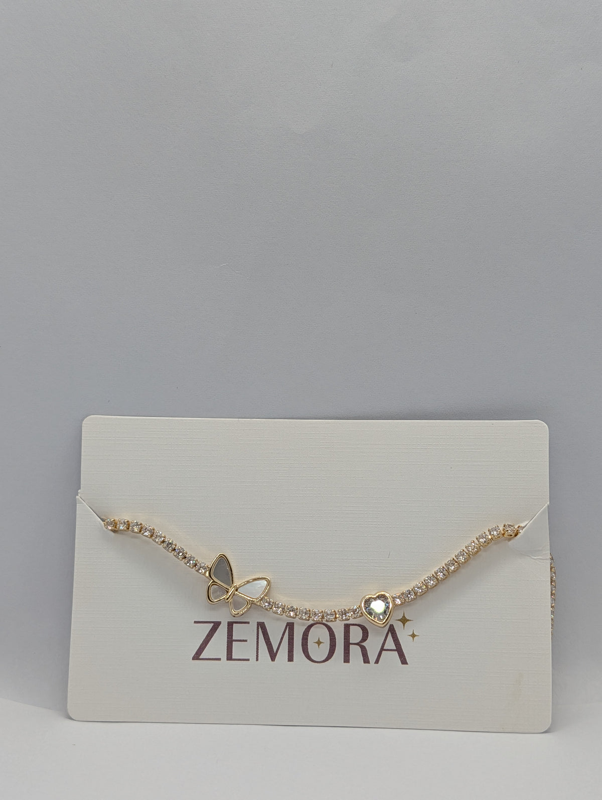 Silver butterfly heart duo station CZ tennis bracelet flat lay showing full length