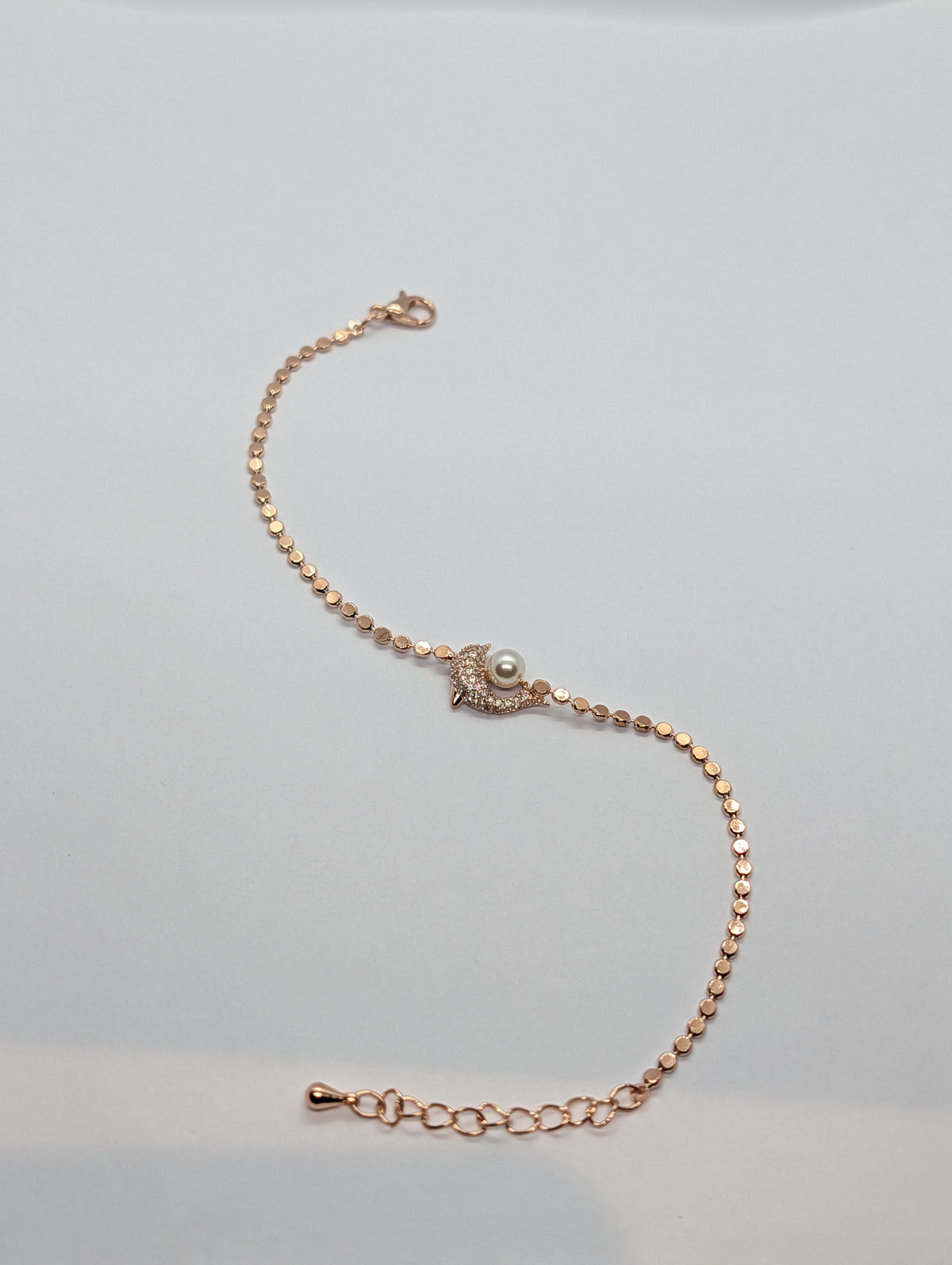Rose gold pavé CZ crescent moon and pearl charm sequin chain bracelet flat lay showing full length and extender chain