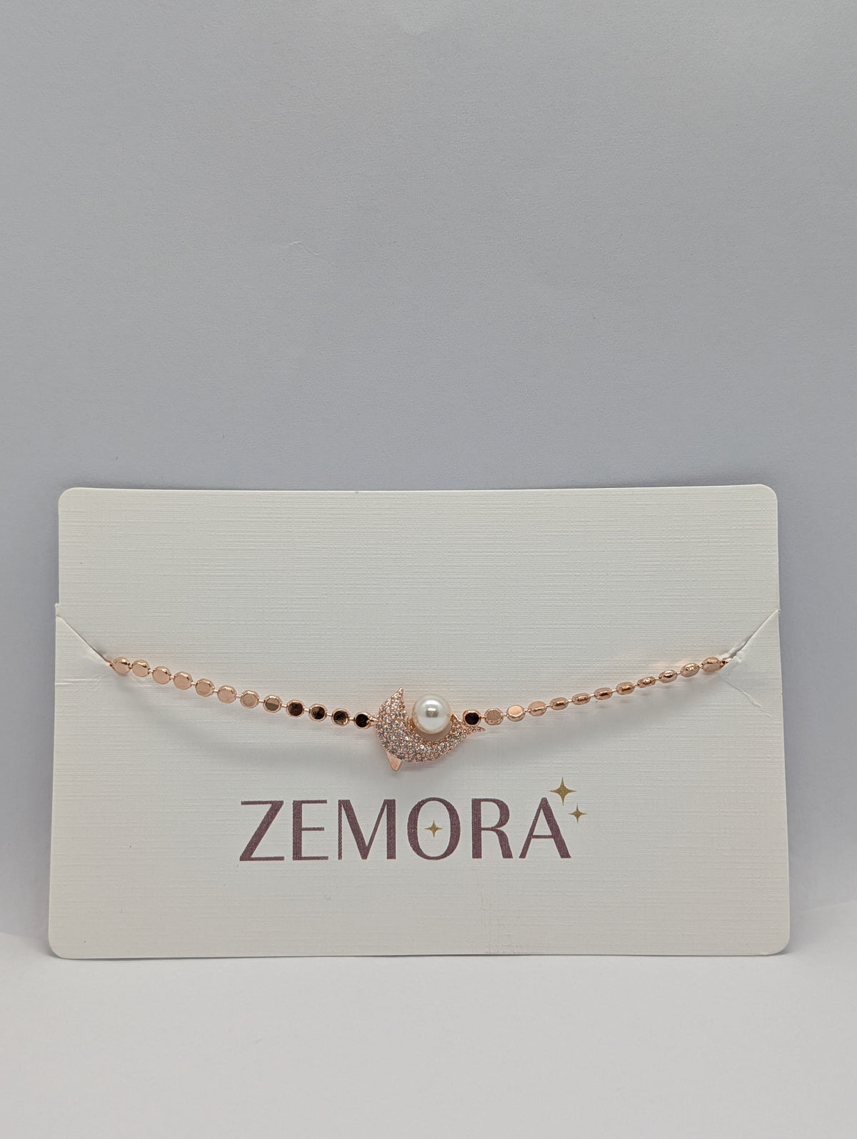 Rose gold pavé CZ crescent moon and pearl charm sequin chain bracelet on Zemora jewellery card