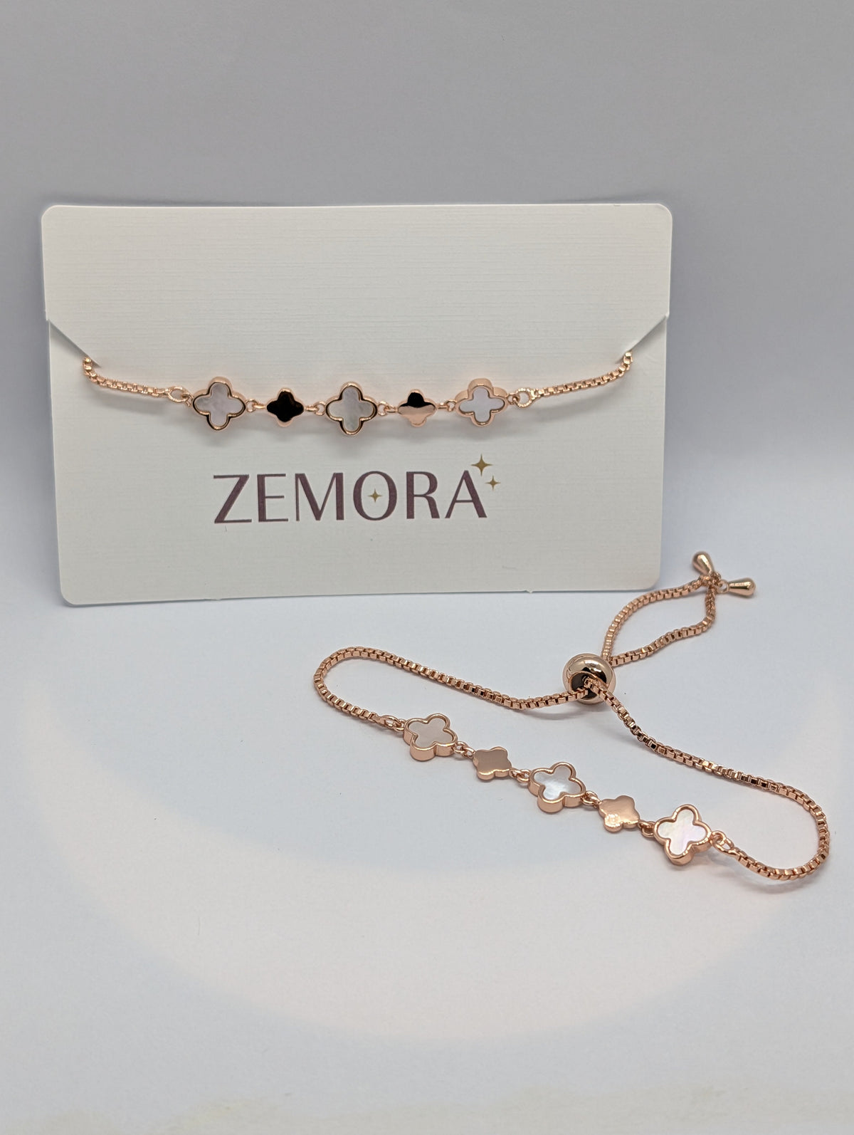 Mother of Pearl Onyx Clover Station Bracelet - Rose Gold tone worn on wrist with palm shadow background