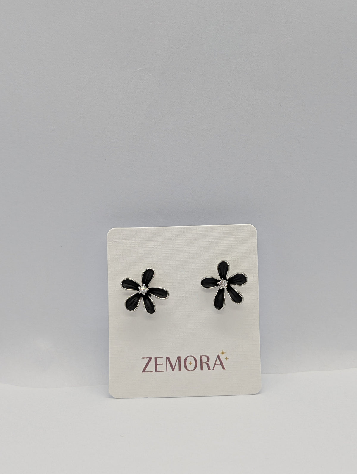 Black Enamel Daisy CZ Centre Stud Earrings - Silver tone on Zemora display card