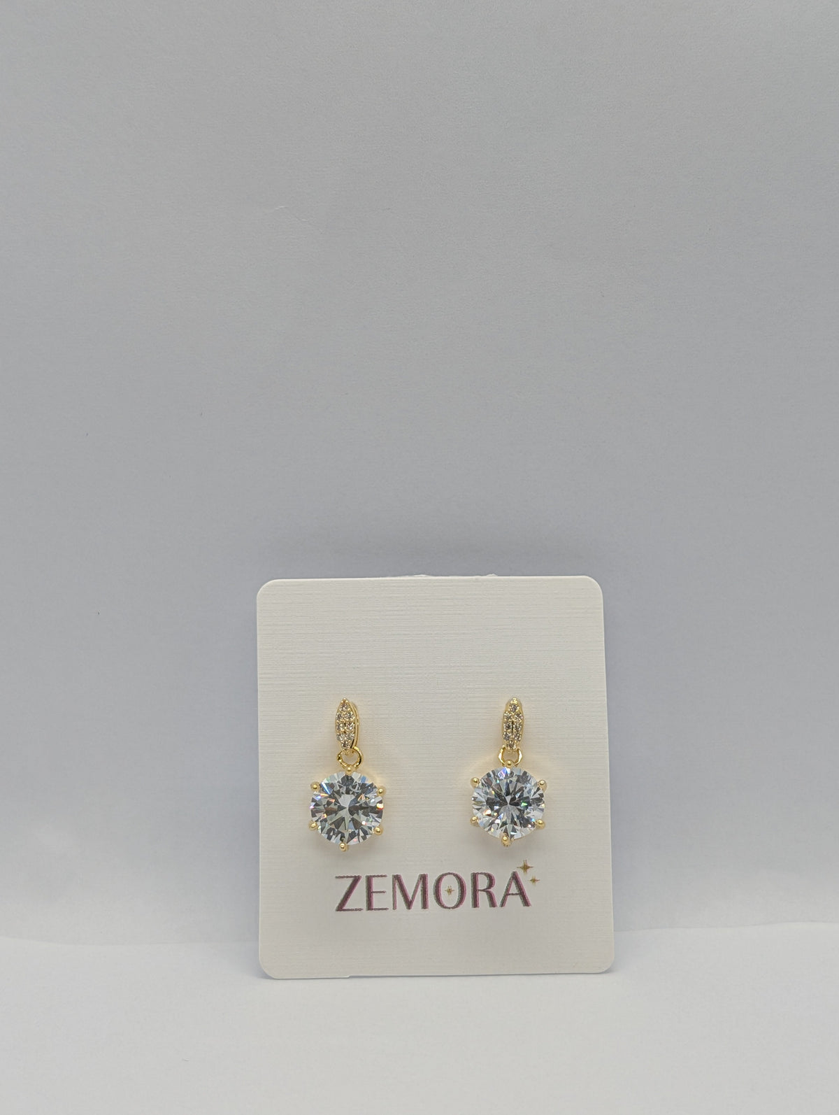 CZ Solitaire Drop Huggie Earrings - Gold tone pair on Zemora card display