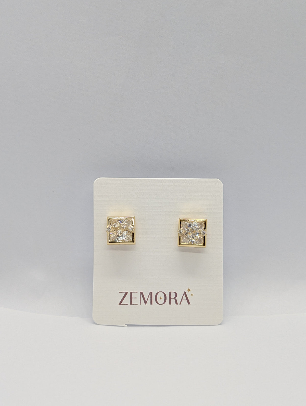 Princess Cut CZ Square Bezel Stud Earrings - Gold tone pair on Zemora card display