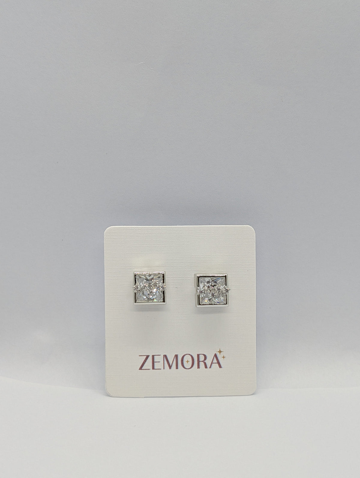 Princess Cut CZ Square Bezel Stud Earrings - Silver tone pair variant on Zemora card display