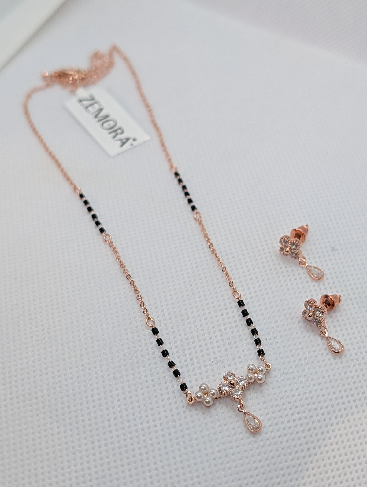 CZ Flower Pearl Cluster Drop Mangalsutra Set - Rose Gold tone pendant and earrings flat lay