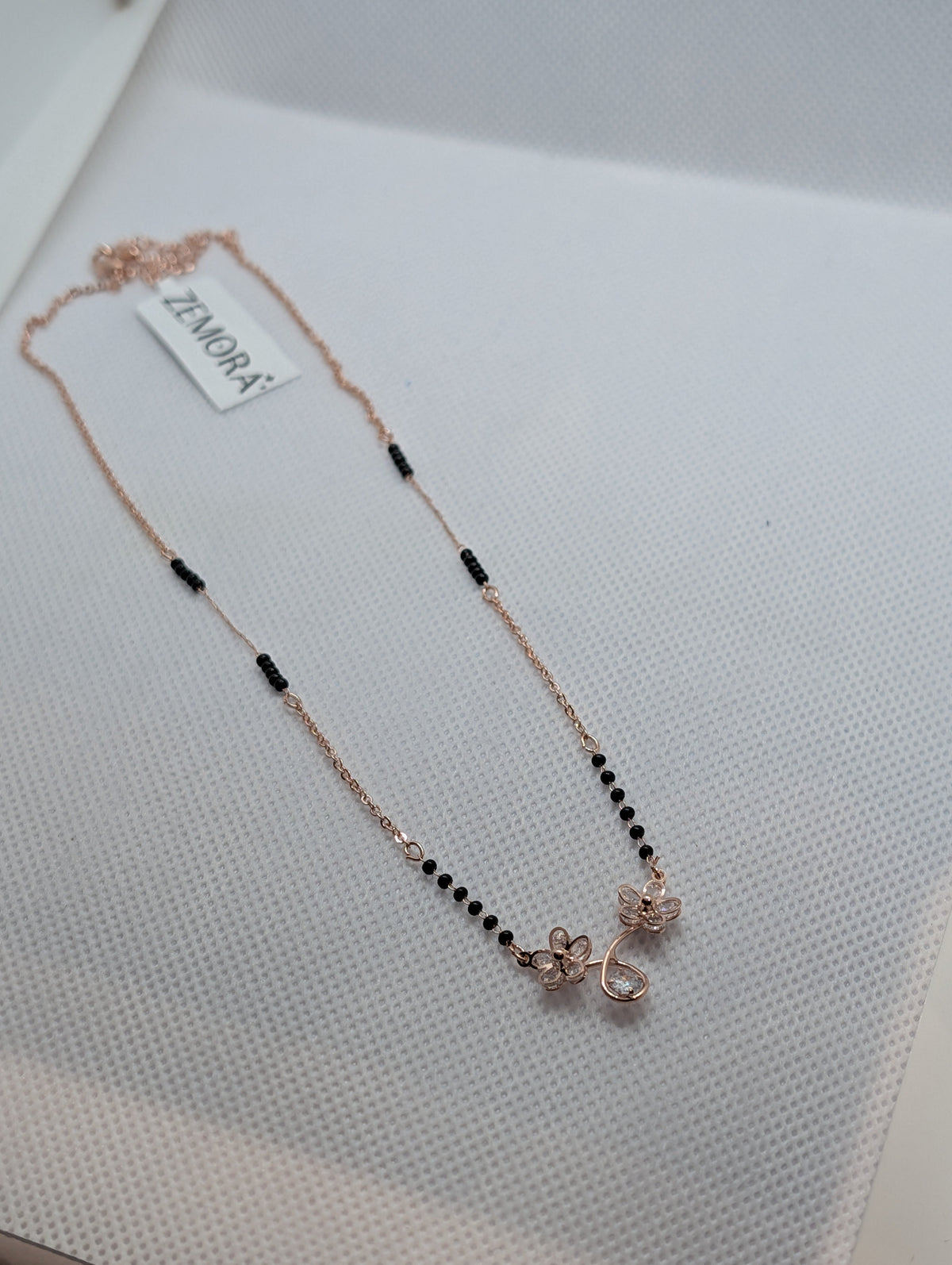 CZ Twin Flower Teardrop Mangalsutra - Rose Gold tone close up pendant view on white fabric display