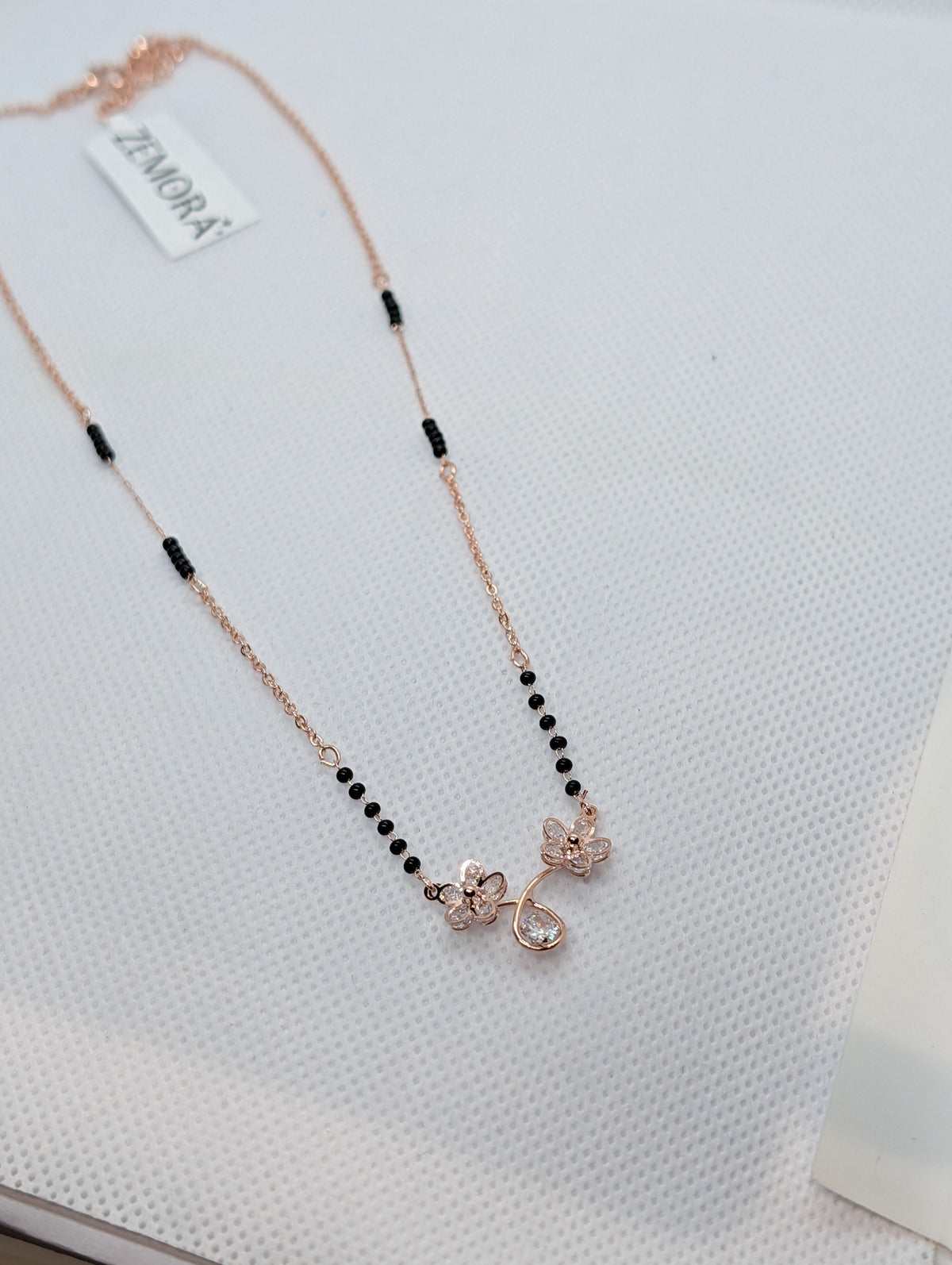 CZ Twin Flower Teardrop Mangalsutra - Rose Gold tone pendant close up angled view on display stand