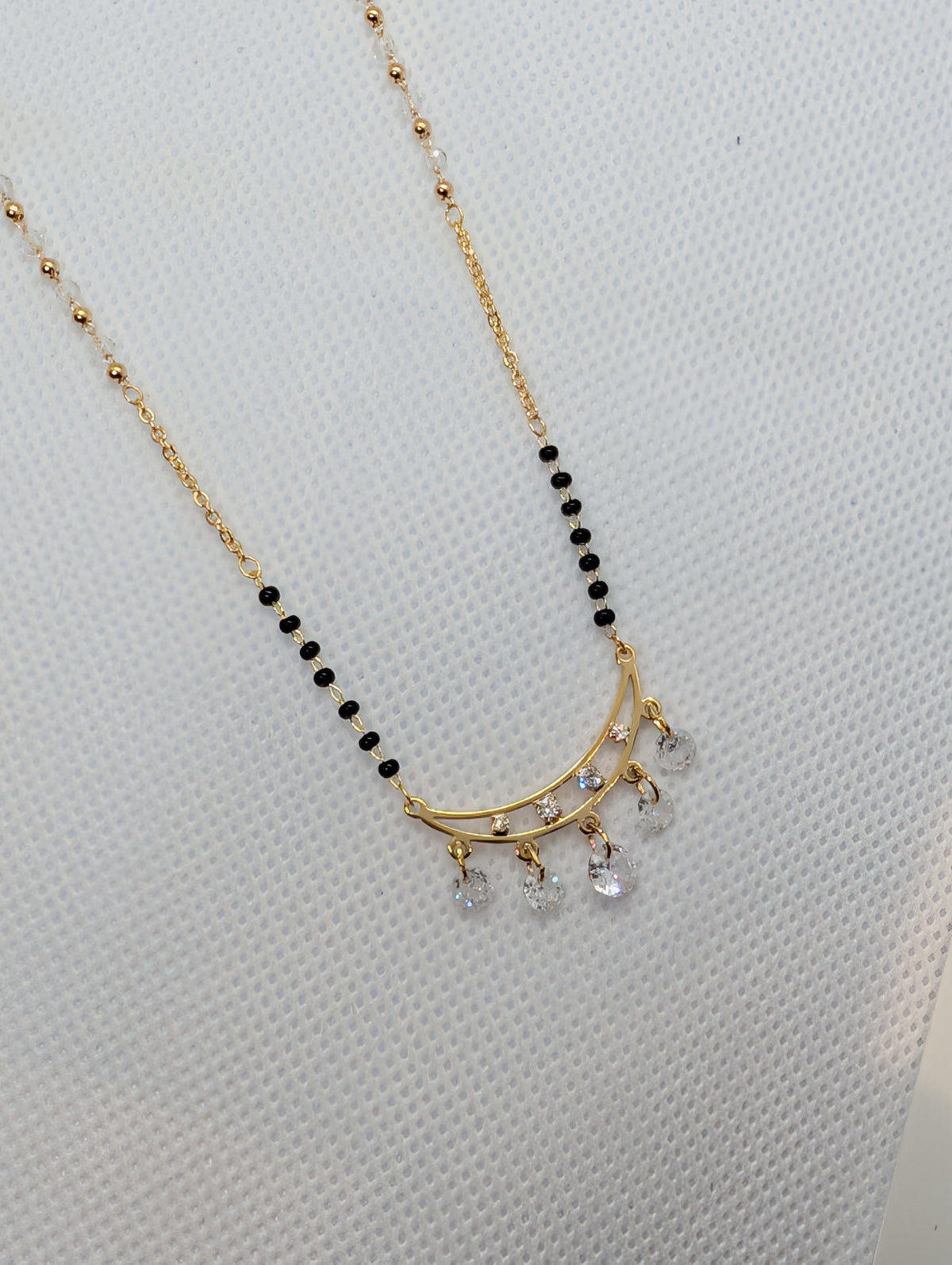 CZ Crescent Arc Multi-Drop Mangalsutra - Gold tone pendant close up on white fabric display