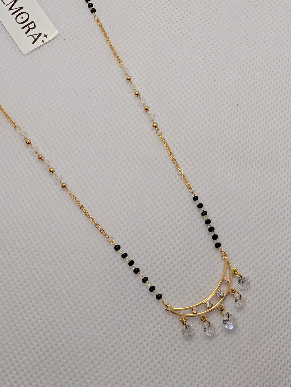 CZ Crescent Arc Multi-Drop Mangalsutra - Gold tone full length angled view on white fabric display
