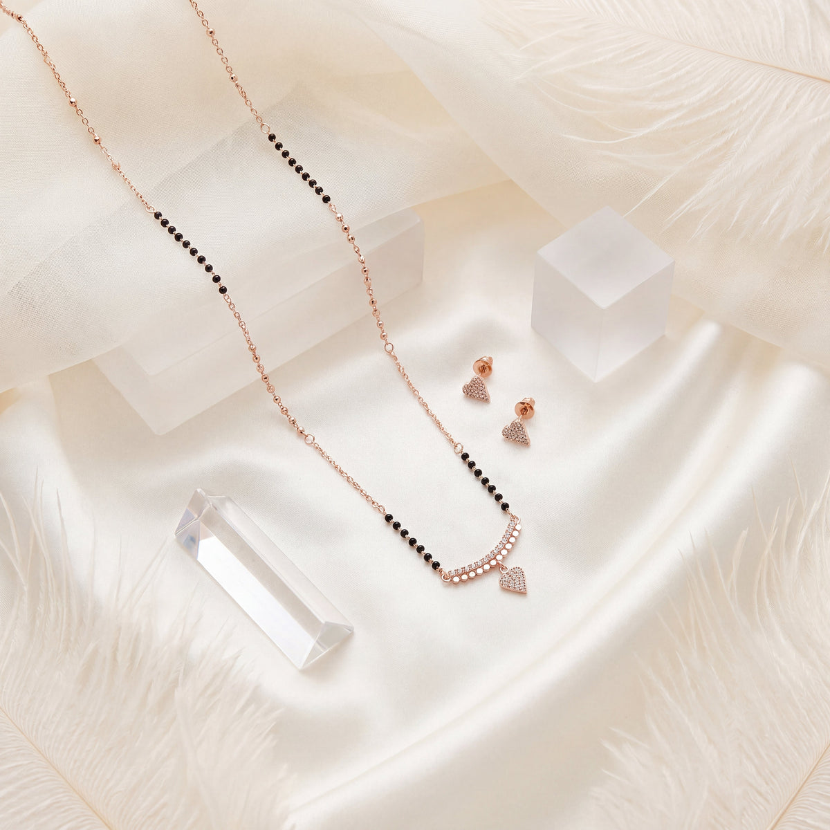 CZ Pave Bar Heart Drop Mangalsutra Set - Rose Gold tone lifestyle flat lay on white silk with crystal
