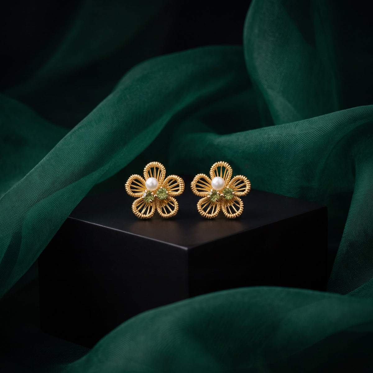 Filigree Flower Pearl Peridot CZ Stud Earrings - Gold tone lifestyle shot on dark block with green silk