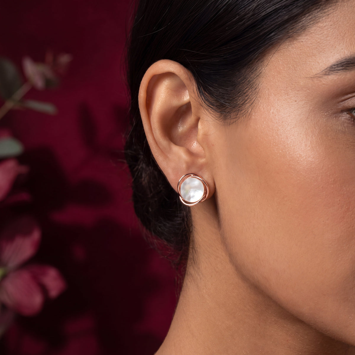 Mother of Pearl Wire Wrap Circle Stud Earrings - Rose Gold tone worn on model ear with crimson foliage background close up