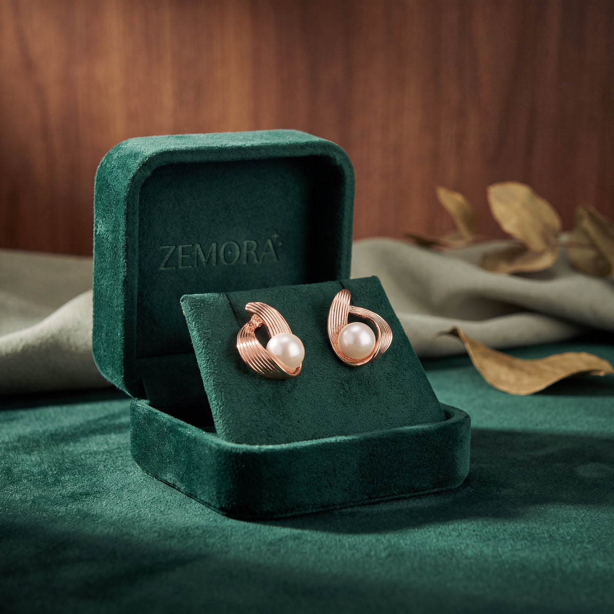 Pearl Ribbed Wire Wrap Stud Earrings - Rose Gold tone in open emerald green Zemora velvet box with golden dry leaves lifestyle shot