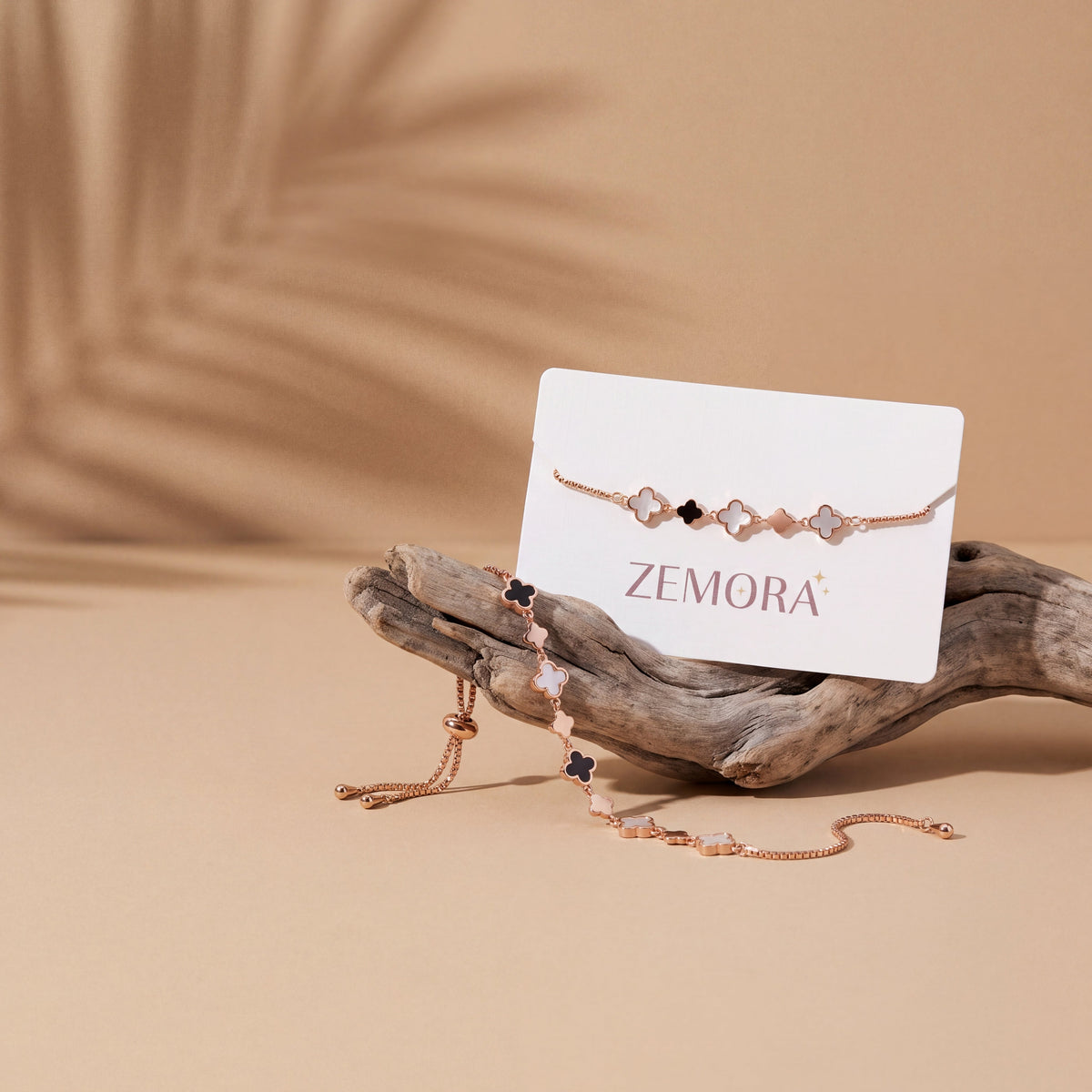 Mother of Pearl Onyx Clover Station Bracelet - Rose Gold tone AI lifestyle shot on sand background