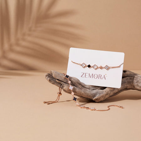 Mother of Pearl Onyx Clover Station Bracelet - Rose Gold tone AI lifestyle shot on sand background
